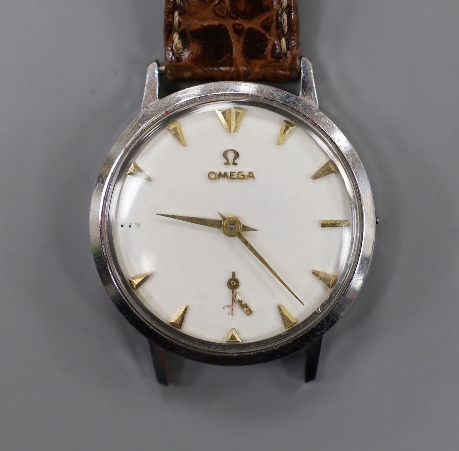 A gentleman's stainless steel Omega manual wind wrist watch, (numeral loose and part of strap missing).